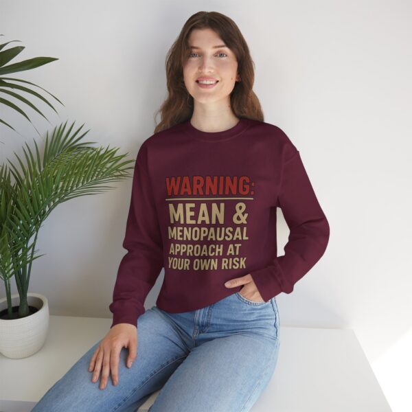 “Warning: Mean and Menopausal – Approach at Your Own Risk” sweatshirt, a cozy and funny statement piece for women embracing perimenopause with humor and attitude.
