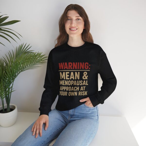 “Warning: Mean and Menopausal – Approach at Your Own Risk” sweatshirt, a cozy and funny statement piece for women embracing perimenopause with humor and attitude.