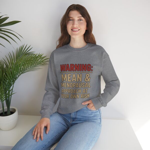 “Warning: Mean and Menopausal – Approach at Your Own Risk” sweatshirt, a cozy and funny statement piece for women embracing perimenopause with humor and attitude.