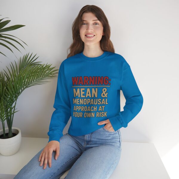 “Warning: Mean and Menopausal – Approach at Your Own Risk” sweatshirt, a cozy and funny statement piece for women embracing perimenopause with humor and attitude.